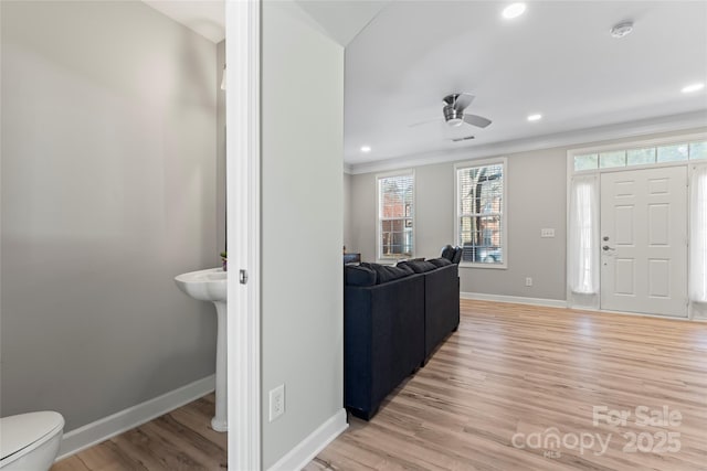 entrance foyer with light hardwood / wood-style floors, ornamental molding, and ceiling fan