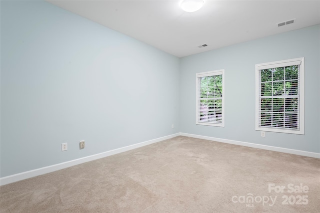 unfurnished room with carpet and baseboards
