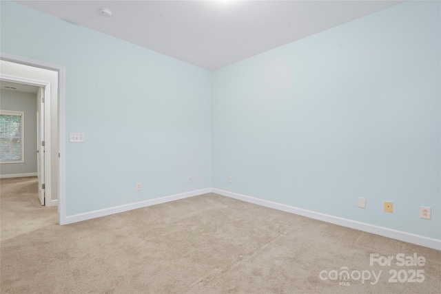 spare room featuring carpet floors and baseboards