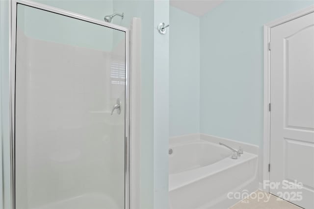 bathroom with a stall shower and a garden tub