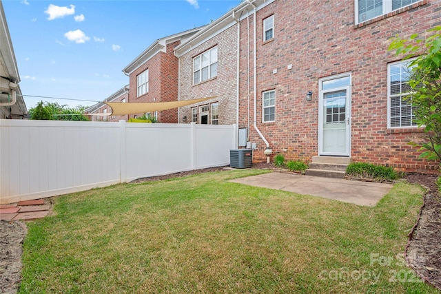 view of yard with entry steps, central air condition unit, and a patio area