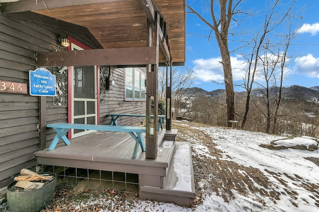 snow covered deck featuring a mountain view