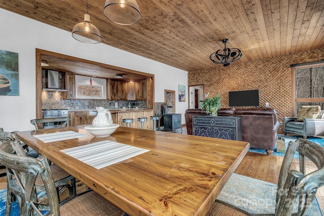 dining area with light wood-type flooring and wooden ceiling