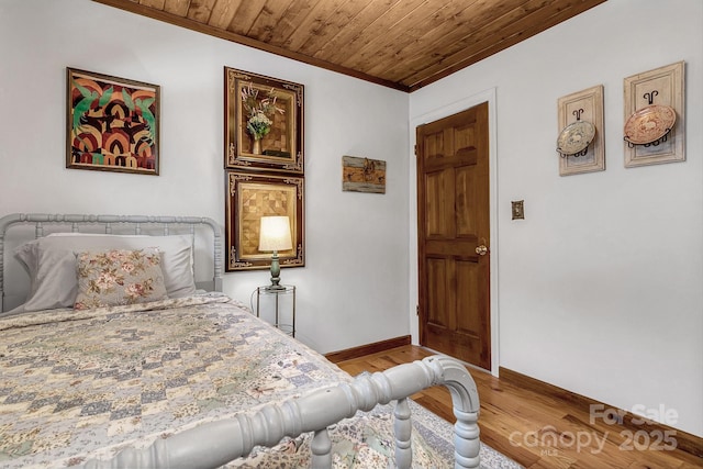 bedroom featuring ornamental molding, hardwood / wood-style floors, and wood ceiling