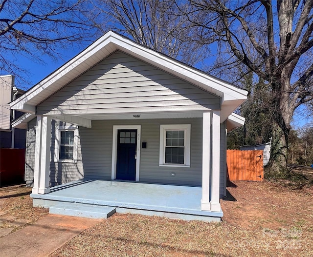 bungalow with covered porch and fence