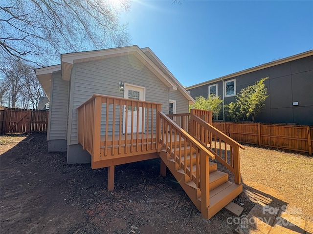 back of property with fence and a deck