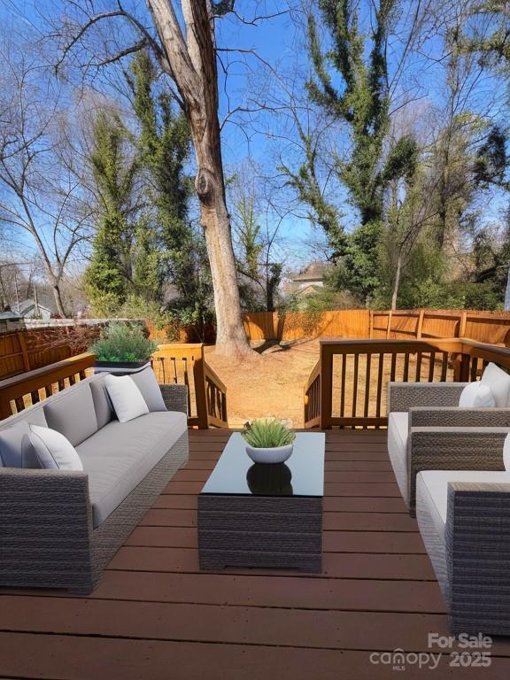 wooden deck featuring a fenced backyard and an outdoor hangout area