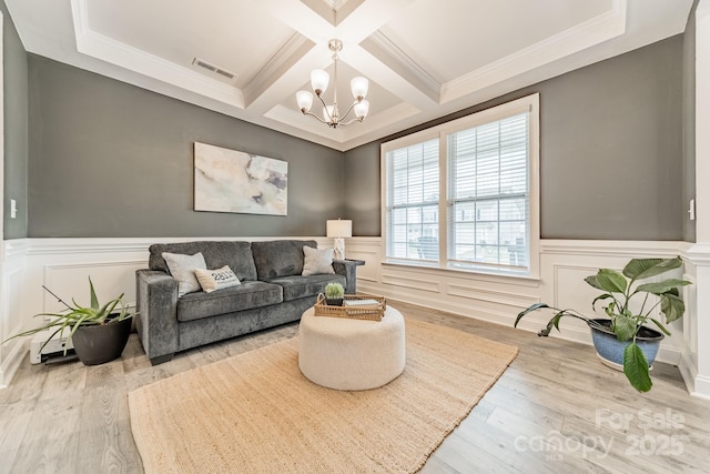 living room with hardwood / wood-style flooring, ornamental molding, coffered ceiling, an inviting chandelier, and beamed ceiling