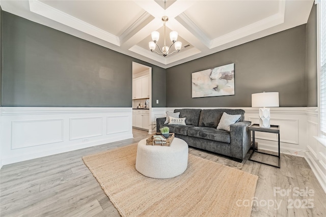 living room with crown molding, light hardwood / wood-style flooring, coffered ceiling, a chandelier, and beamed ceiling