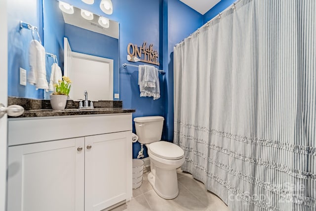 bathroom featuring toilet, vanity, and tile patterned flooring