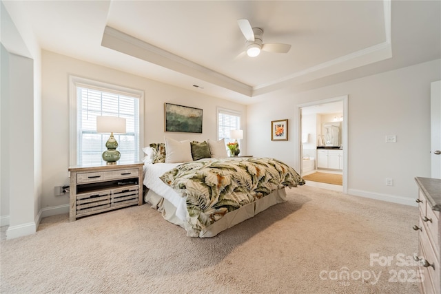 bedroom featuring connected bathroom, ceiling fan, a raised ceiling, and light colored carpet