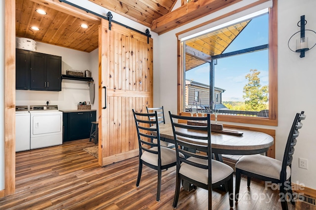 dining area featuring separate washer and dryer, vaulted ceiling, wooden ceiling, dark hardwood / wood-style flooring, and a barn door