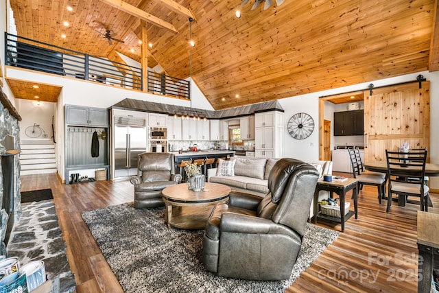 living room with beamed ceiling, ceiling fan, wood ceiling, and high vaulted ceiling