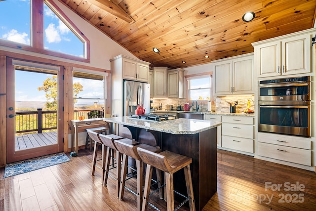 kitchen with a kitchen island, tasteful backsplash, wood ceiling, stainless steel appliances, and light stone countertops