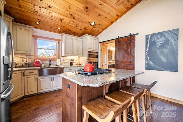 kitchen with a kitchen island, sink, backsplash, light stone counters, and stainless steel appliances