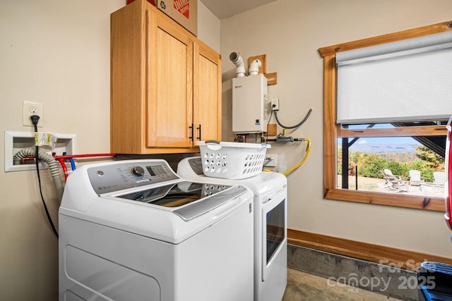 clothes washing area featuring water heater, independent washer and dryer, and cabinets