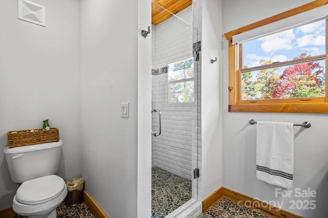 bathroom featuring walk in shower, a healthy amount of sunlight, and toilet