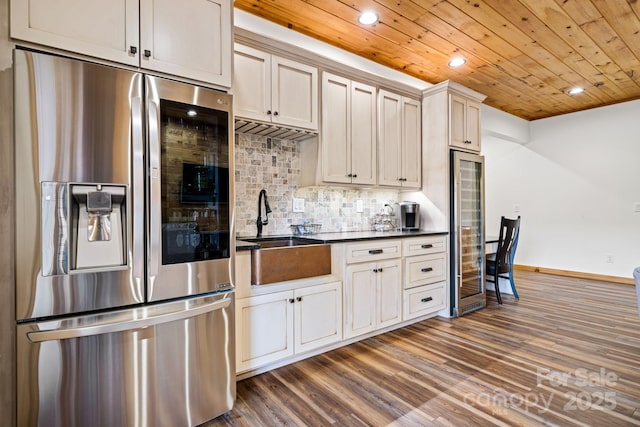 kitchen featuring sink, wood ceiling, tasteful backsplash, dark hardwood / wood-style floors, and stainless steel fridge