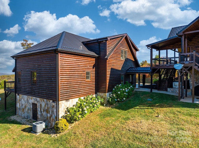 view of side of property featuring a deck, central air condition unit, and a lawn