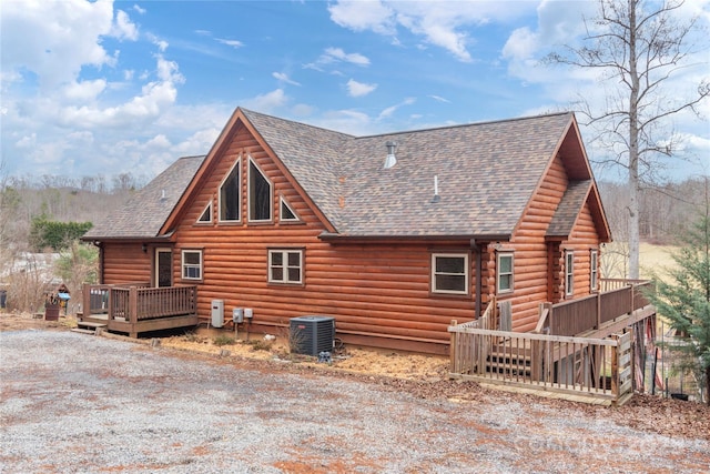 rear view of property featuring a wooden deck and central AC