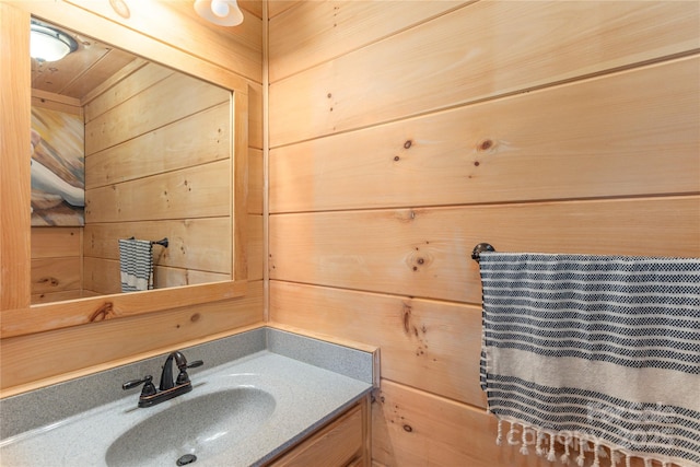 bathroom featuring vanity and wooden walls