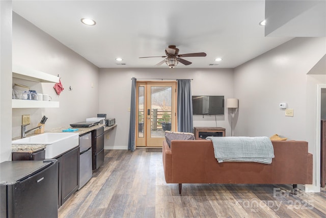 living room with ceiling fan, dark hardwood / wood-style floors, and sink