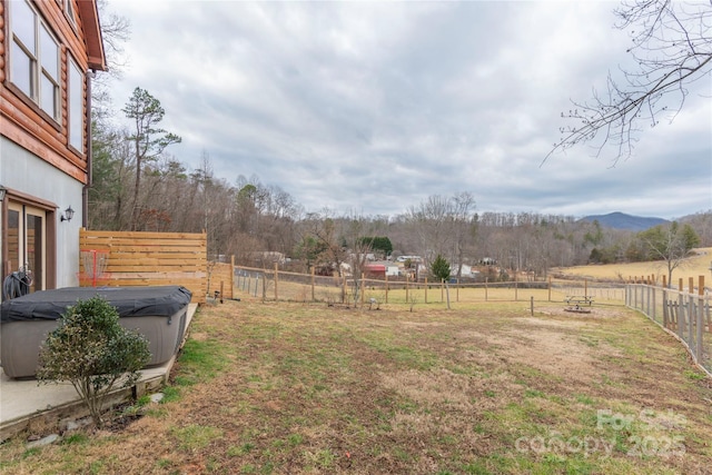 view of yard with a hot tub and a mountain view