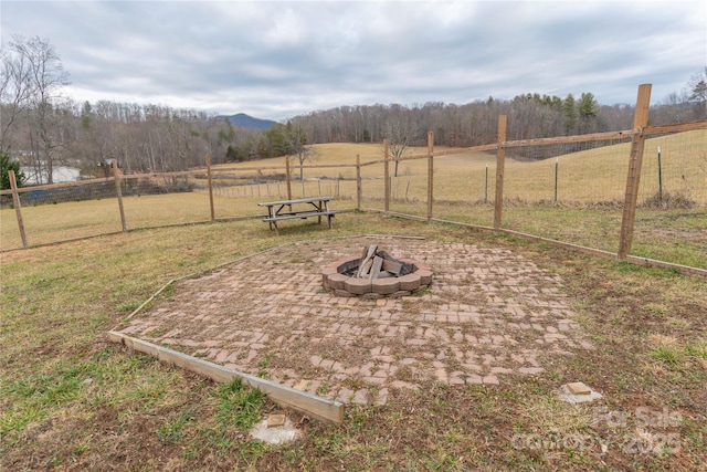 view of yard featuring a rural view and a fire pit