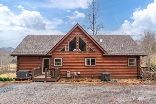 rear view of property with a wooden deck and cooling unit