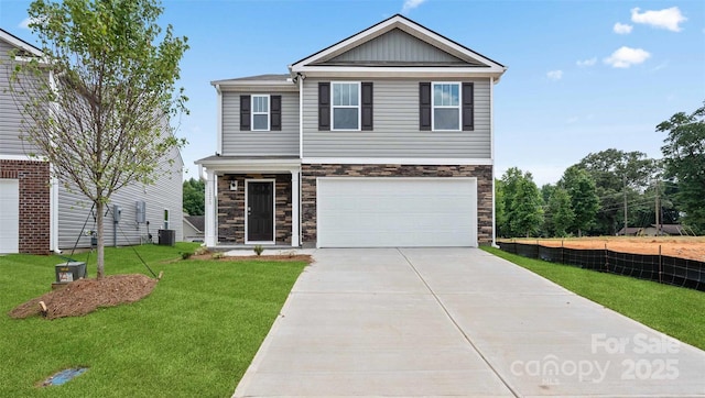 view of front of property with a garage, cooling unit, and a front lawn