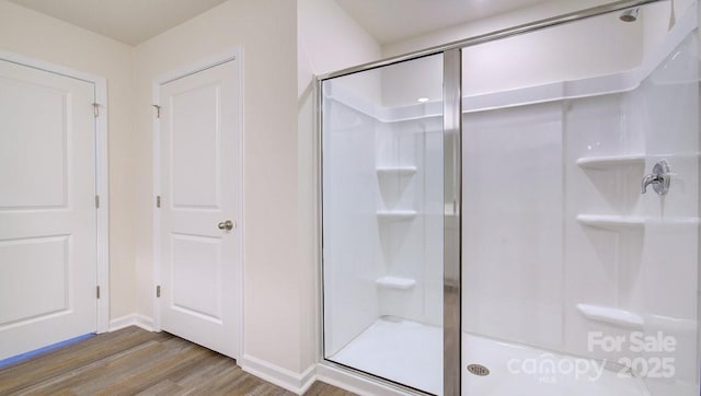 bathroom with hardwood / wood-style flooring and walk in shower