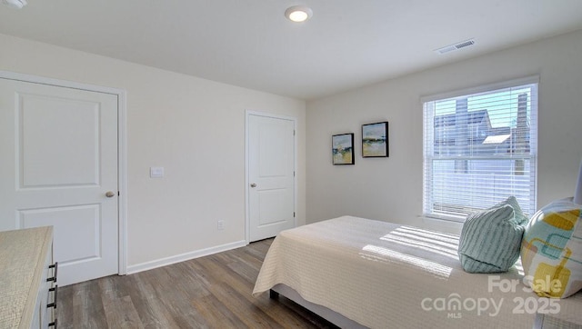 bedroom with dark hardwood / wood-style flooring