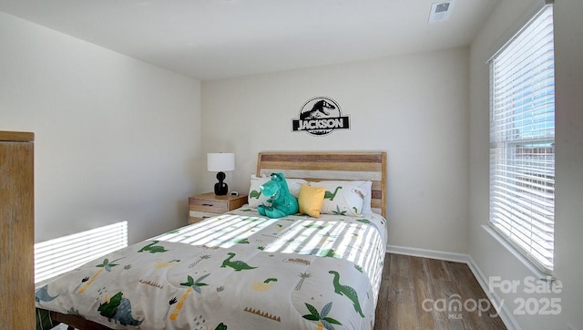 bedroom featuring hardwood / wood-style flooring and multiple windows