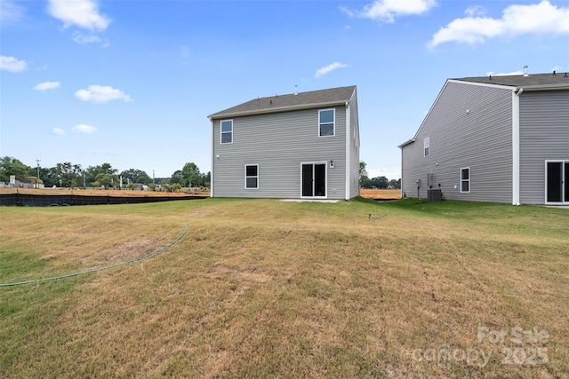 back of property featuring central AC unit and a lawn