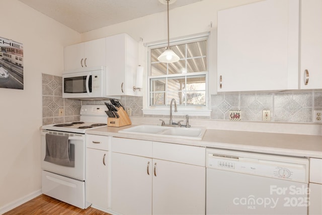 kitchen featuring sink, white cabinetry, tasteful backsplash, decorative light fixtures, and white appliances