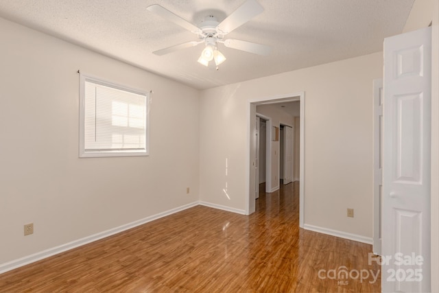 spare room featuring ceiling fan, wood-type flooring, and a textured ceiling