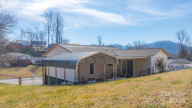 rear view of house with a carport and a mountain view