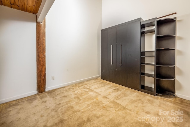 unfurnished bedroom with wood ceiling and light colored carpet