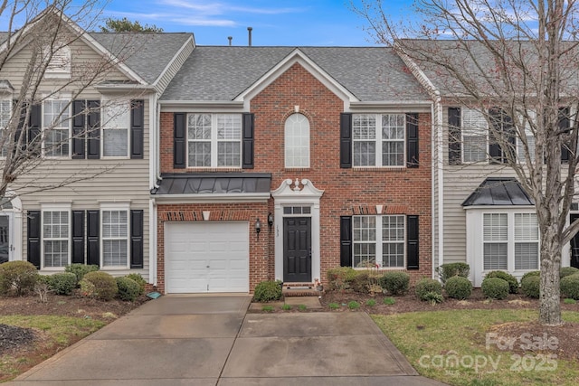 townhome / multi-family property with a standing seam roof, a shingled roof, concrete driveway, a garage, and brick siding