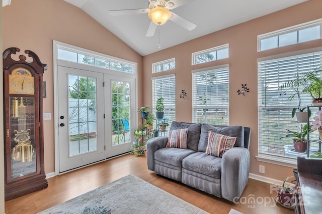 interior space with ceiling fan, baseboards, lofted ceiling, and wood finished floors