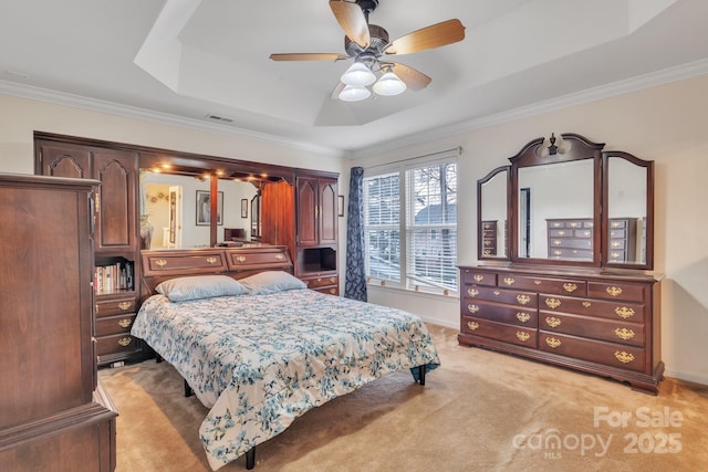 bedroom with visible vents, crown molding, baseboards, light carpet, and a raised ceiling