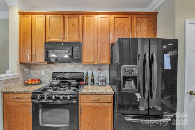 kitchen featuring black appliances, light stone counters, crown molding, and backsplash