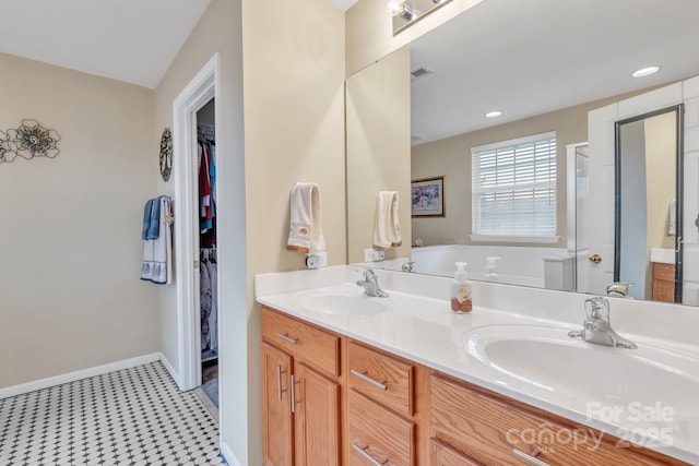 bathroom featuring a sink, baseboards, and double vanity