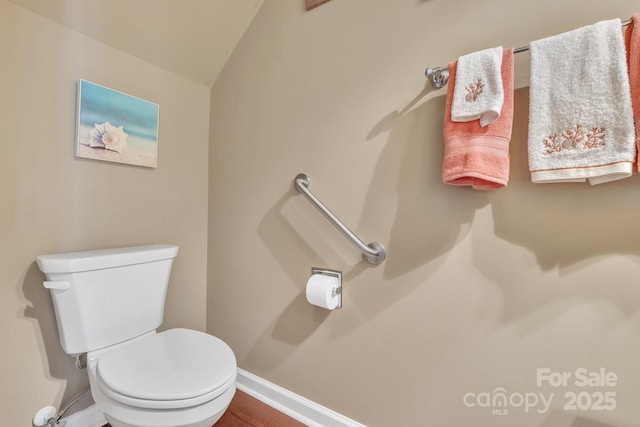 bathroom featuring vaulted ceiling, toilet, and baseboards