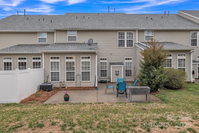 back of house featuring a patio area, roof with shingles, a yard, and fence