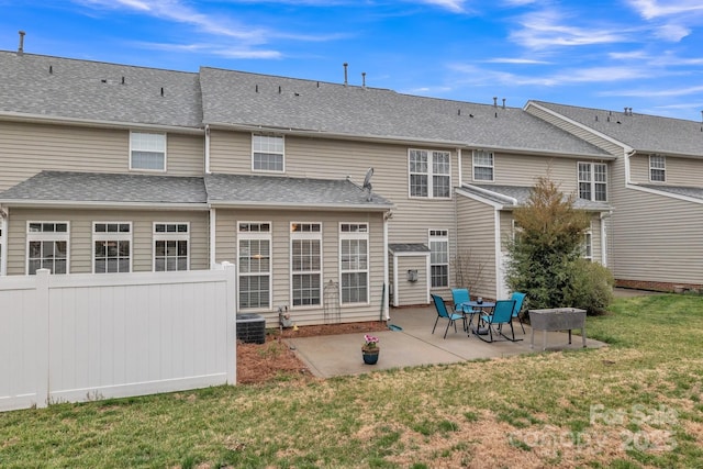 back of house with a shingled roof, fence, central AC, a lawn, and a patio