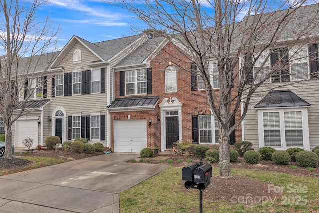 view of front of home featuring brick siding, a shingled roof, concrete driveway, a garage, and a standing seam roof