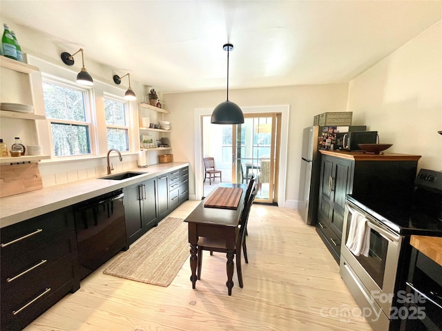 kitchen featuring pendant lighting, sink, dishwasher, light hardwood / wood-style floors, and stainless steel electric stove