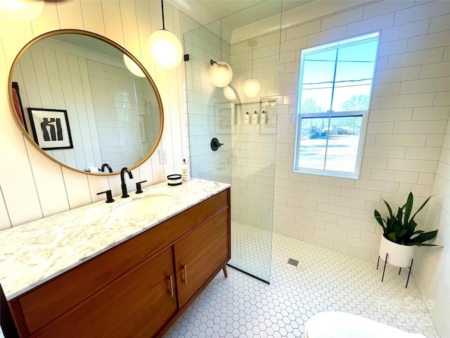 bathroom featuring vanity, a tile shower, and tile patterned floors