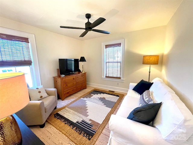 living room with light hardwood / wood-style flooring and ceiling fan